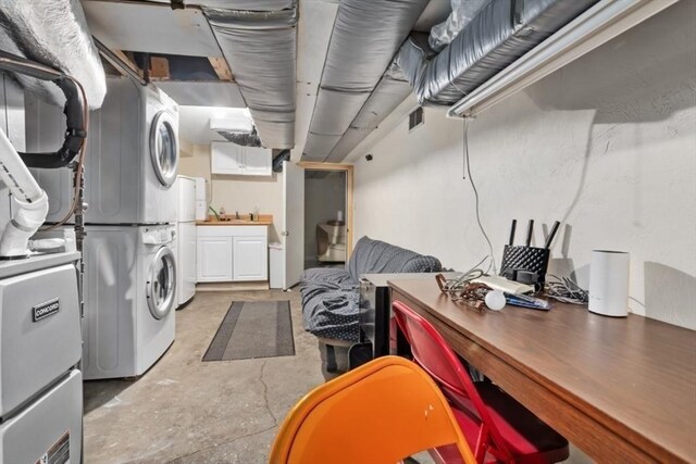 laundry room with cabinet space, visible vents, stacked washer and clothes dryer, and a sink