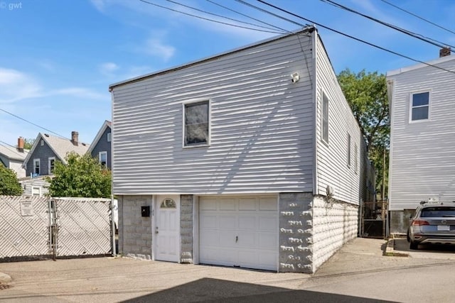view of front of home with an attached garage, driveway, fence, and a gate