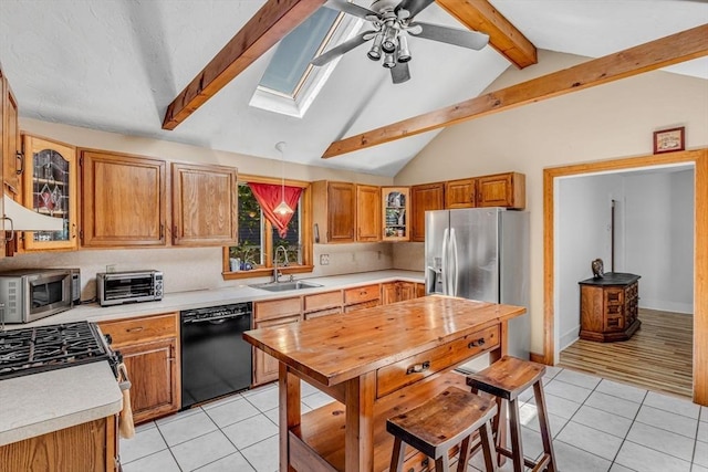 66 Guinan St, Waltham, MA 02451 - kitchen featuring stainless steel appliances, a skylight, light tile patterned floors, light countertops, and ceiling fan