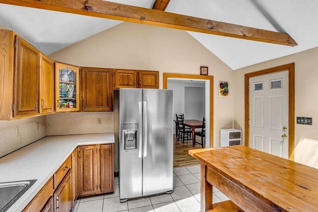 66 Guinan St, Waltham, MA 02451 - kitchen with stainless steel refrigerator with ice dispenser, light tile patterned floors, light countertops, and brown cabinetry
