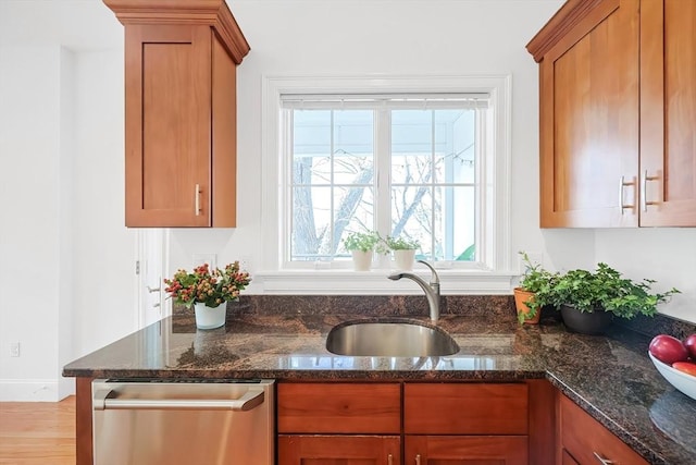 kitchen with a sink, brown cabinets, and dishwasher