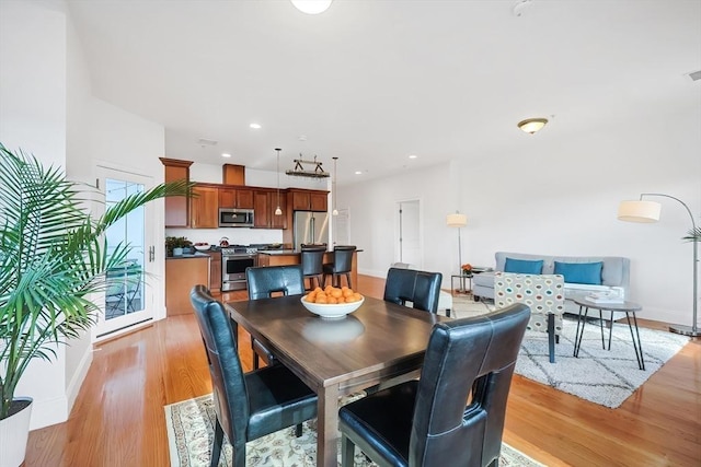 dining room with light wood finished floors, visible vents, recessed lighting, and baseboards