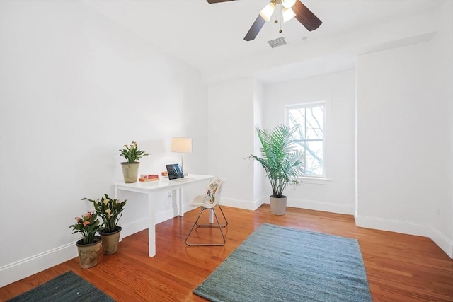 office area featuring ceiling fan, wood finished floors, visible vents, and baseboards