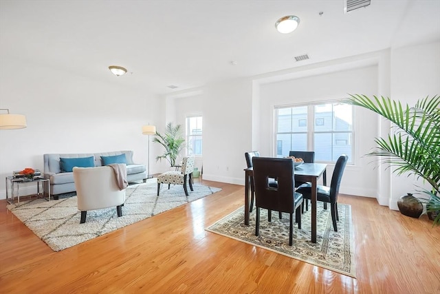 dining room featuring visible vents, baseboards, and wood finished floors