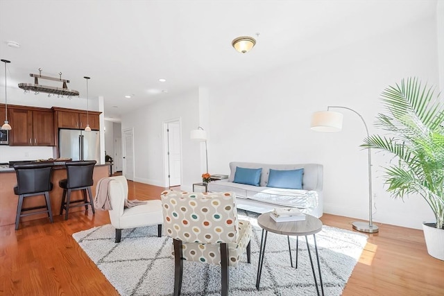 living room featuring recessed lighting, light wood-style flooring, and baseboards