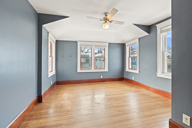 unfurnished room featuring a ceiling fan, light wood-style flooring, and baseboards