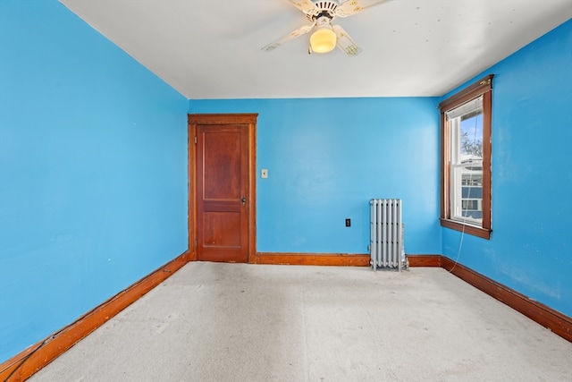 unfurnished room with radiator heating unit, baseboards, and a ceiling fan