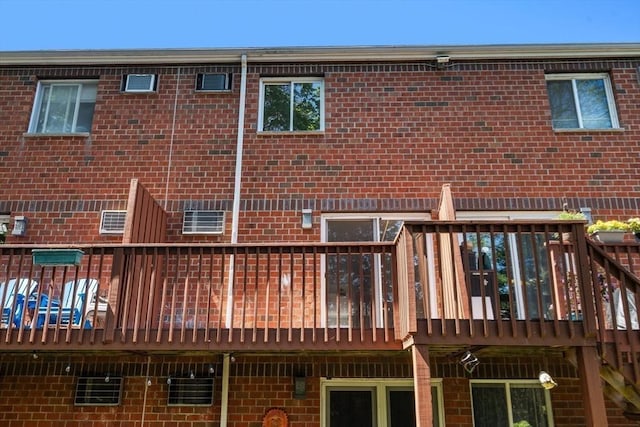 rear view of house with a wooden deck and brick siding