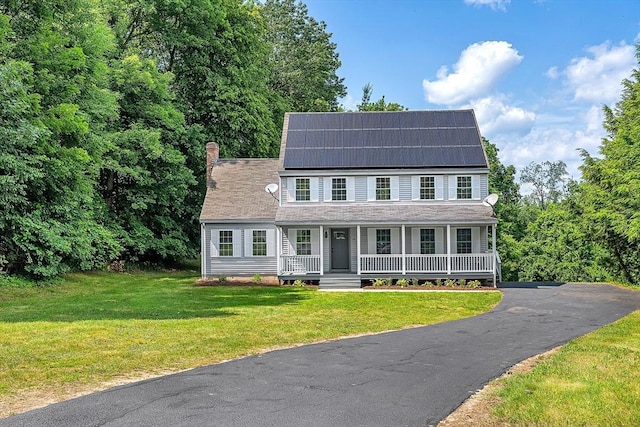 69 Biscuit Hill Dr, Leominster, MA 01453 - view of front of house featuring covered porch, solar panels, a chimney, a front lawn, and roof with shingles