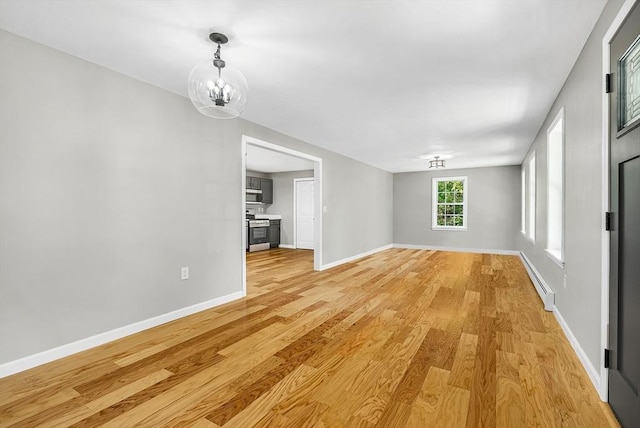 69 Biscuit Hill Dr, Leominster, MA 01453 - unfurnished living room with a chandelier, light wood finished floors, and a baseboard radiator