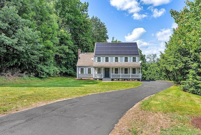 69 Biscuit Hill Dr, Leominster, MA 01453 - view of front of home with a porch, roof mounted solar panels, a front lawn, and a chimney