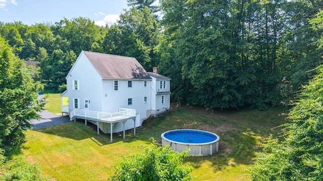 69 Biscuit Hill Dr, Leominster, MA 01453 - rear view of house featuring a chimney, an outdoor pool, a lawn, a deck, and roof with shingles