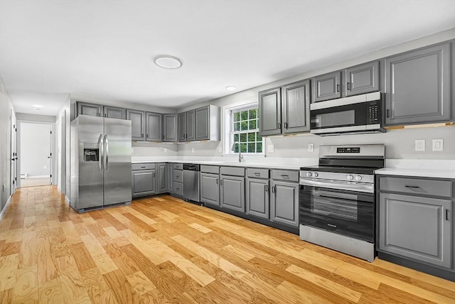 69 Biscuit Hill Dr, Leominster, MA 01453 - kitchen with appliances with stainless steel finishes, gray cabinetry, light wood-type flooring, light countertops, and recessed lighting