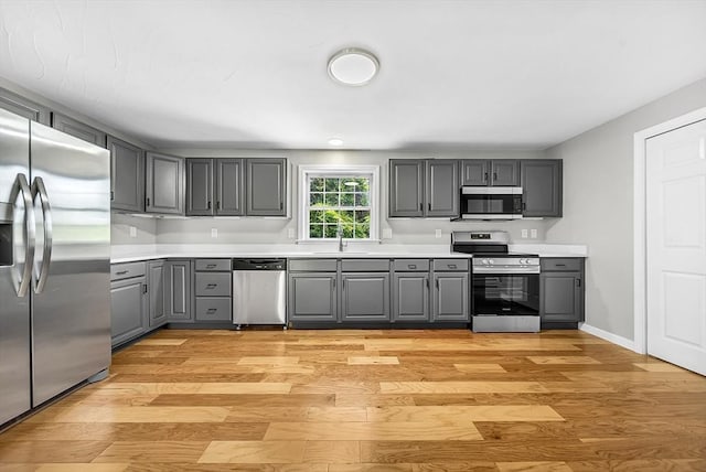 69 Biscuit Hill Dr, Leominster, MA 01453 - kitchen with appliances with stainless steel finishes, gray cabinetry, light wood-type flooring, and light countertops