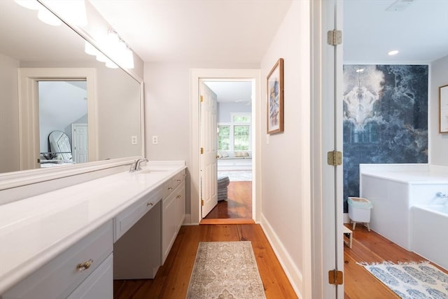 338 Highland St, Weston, MA 02493 - full bath with wood finished floors, vanity, a garden tub, and baseboards