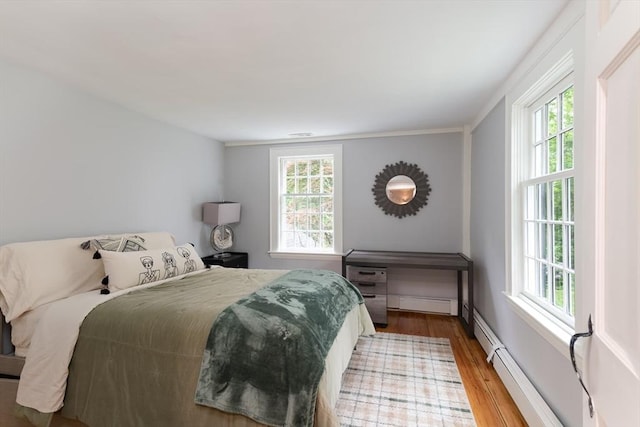 338 Highland St, Weston, MA 02493 - bedroom featuring wood finished floors, multiple windows, baseboard heating, crown molding, and baseboards