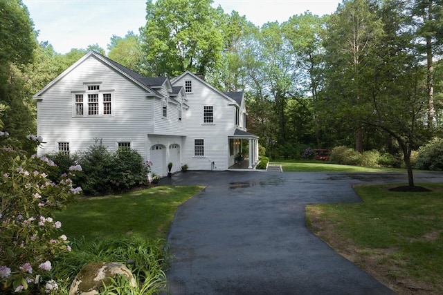 338 Highland St, Weston, MA 02493 - view of front of home featuring driveway, a front lawn, an attached garage, and view of wooded area