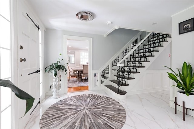 338 Highland St, Weston, MA 02493 - entryway featuring stairway, a decorative wall, marble finish flooring, a wainscoted wall, and crown molding