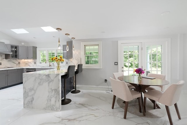 338 Highland St, Weston, MA 02493 - dining area with plenty of natural light, light marble finish floors, and a skylight