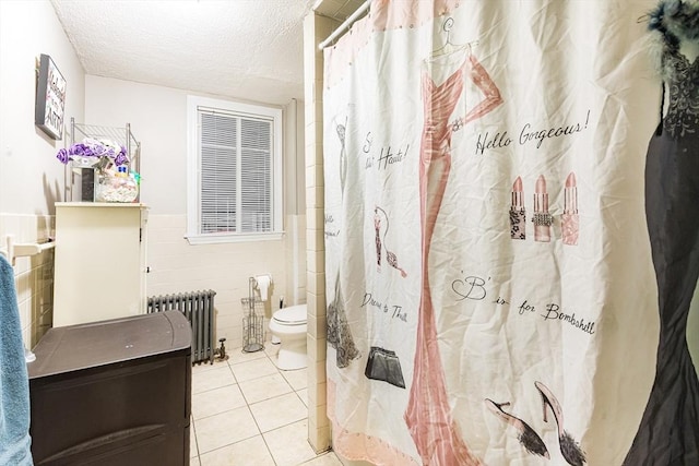 bathroom with radiator, tile walls, tile patterned flooring, toilet, and a textured ceiling