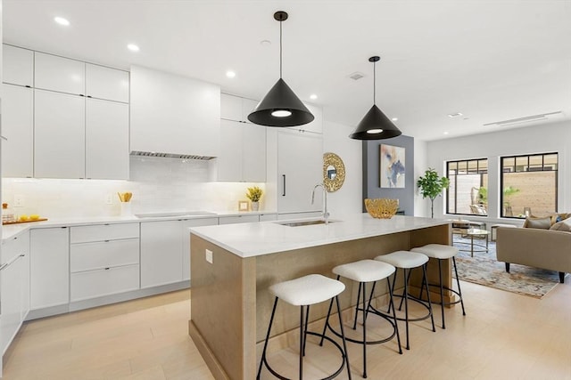 145 Warren St Unit 5, Newton, MA 02459 - kitchen featuring white cabinets, tasteful backsplash, a kitchen breakfast bar, light countertops, and recessed lighting