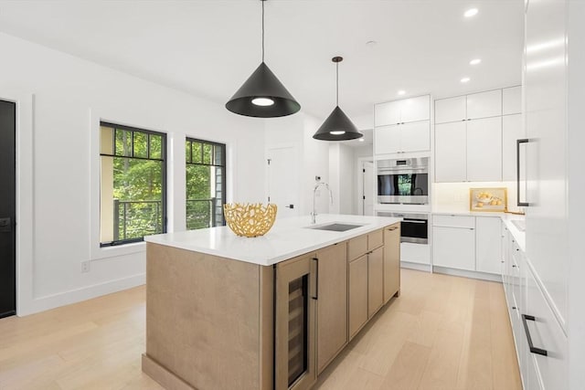 145 Warren St Unit 5, Newton, MA 02459 - kitchen with wine cooler, light wood finished floors, modern cabinets, stainless steel double oven, and recessed lighting