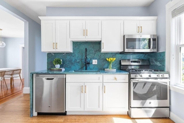 41 Sudan St Unit 3, Boston, MA 02125 - kitchen featuring stainless steel appliances, healthy amount of natural light, light wood finished floors, and white cabinetry