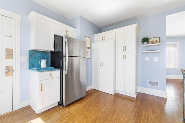 41 Sudan St Unit 3, Boston, MA 02125 - kitchen with freestanding refrigerator, light wood-style flooring, white cabinetry, and backsplash