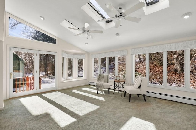 unfurnished sunroom with ceiling fan, vaulted ceiling with skylight, and a baseboard heating unit