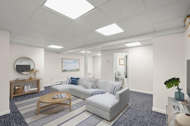 carpeted living room with a baseboard radiator and a drop ceiling