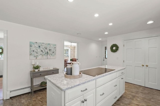 kitchen with white cabinets, a baseboard heating unit, a center island, black electric stovetop, and light stone counters