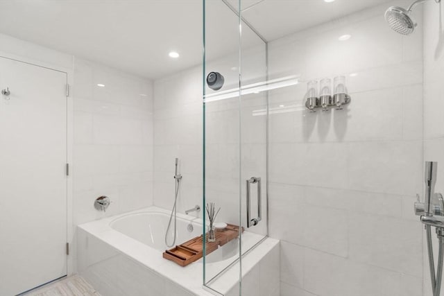 bathroom with a stall shower and a garden tub