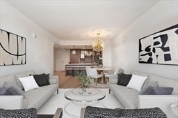 living room featuring wood-type flooring and a notable chandelier