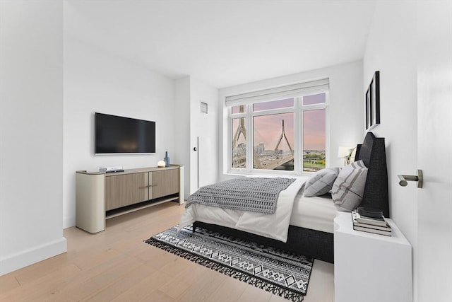 bedroom featuring light wood-style floors, baseboards, and visible vents