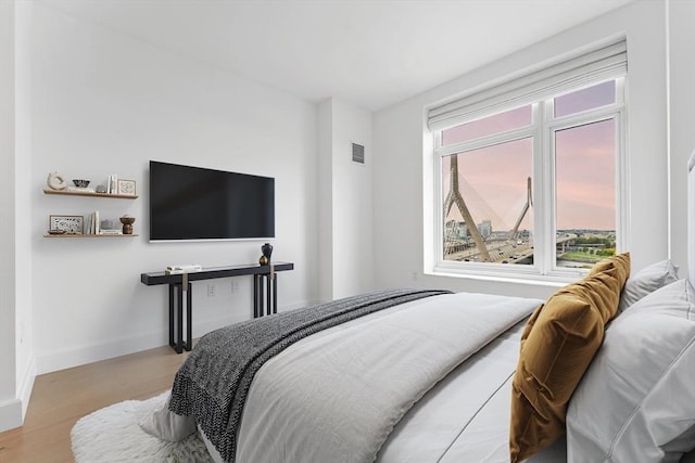 bedroom featuring baseboards, visible vents, and wood finished floors