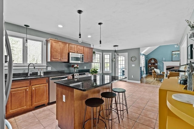 kitchen featuring a kitchen island, appliances with stainless steel finishes, light tile patterned flooring, and a breakfast bar