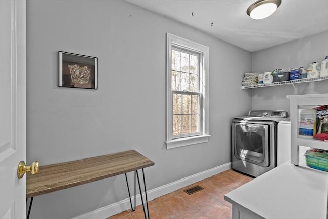 clothes washing area featuring light tile patterned floors, visible vents, baseboards, laundry area, and separate washer and dryer