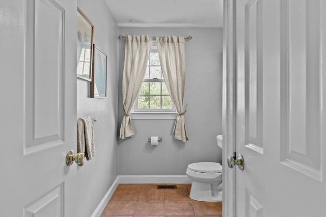 bathroom featuring tile patterned flooring, toilet, baseboards, and visible vents