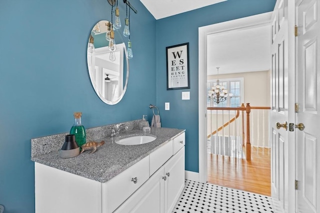 bathroom with vanity, a notable chandelier, and baseboards