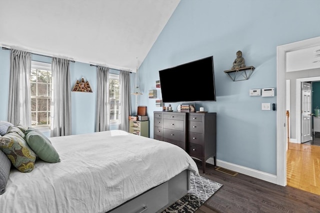 bedroom with dark wood-style floors, visible vents, baseboards, and lofted ceiling