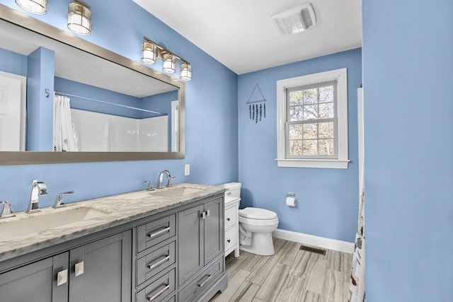 full bath featuring baseboards, visible vents, and a sink