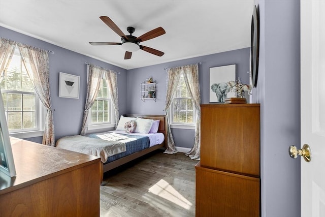 bedroom with baseboards, a ceiling fan, and wood finished floors