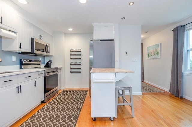 300 Falmouth Rd Unit 12A, Mashpee, MA 02649 - kitchen featuring appliances with stainless steel finishes, light wood-style floors, light countertops, recessed lighting, and white cabinets