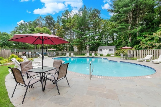 300 Falmouth Rd Unit 12A, Mashpee, MA 02649 - view of swimming pool featuring a patio, a storage shed, and view of scattered trees