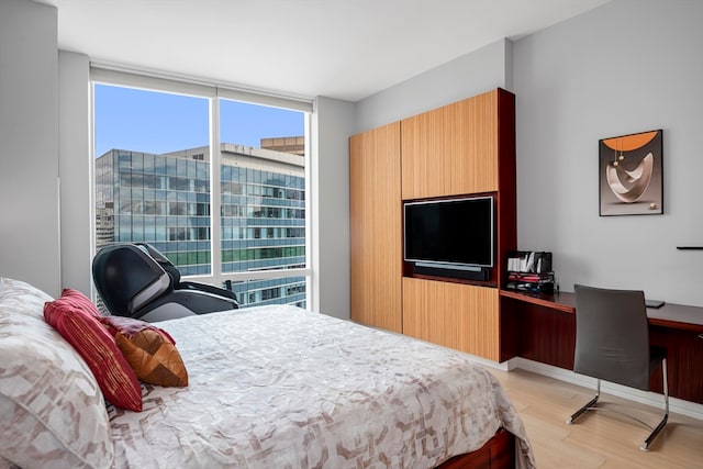 bedroom featuring multiple windows and light wood-type flooring