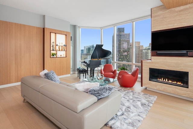 living room with a fireplace, light hardwood / wood-style flooring, and expansive windows