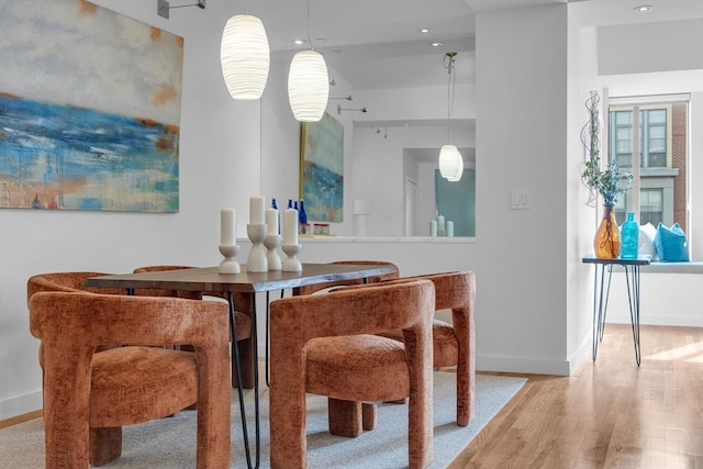 bar featuring hanging light fixtures, baseboards, wood finished floors, and recessed lighting