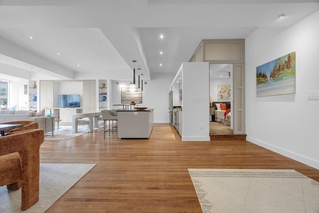 living room featuring light wood-style flooring, baseboards, and recessed lighting