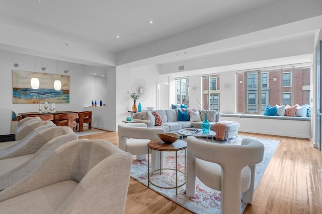 living room with baseboards, recessed lighting, and light wood-style floors