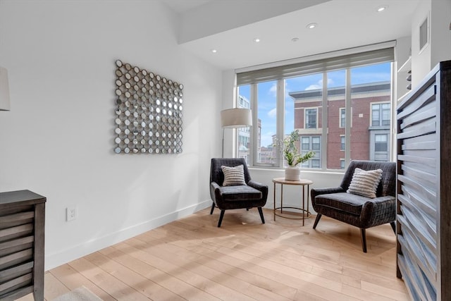 living area with light wood finished floors, recessed lighting, and baseboards